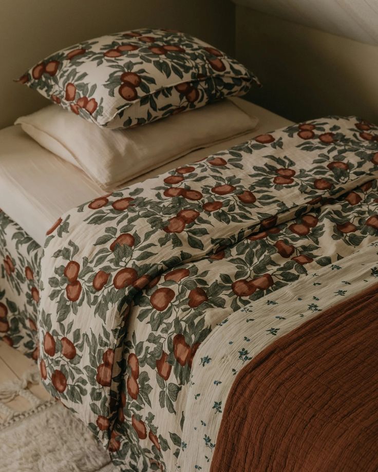 a bed with two pillows on top of it next to a blanket and pillow case