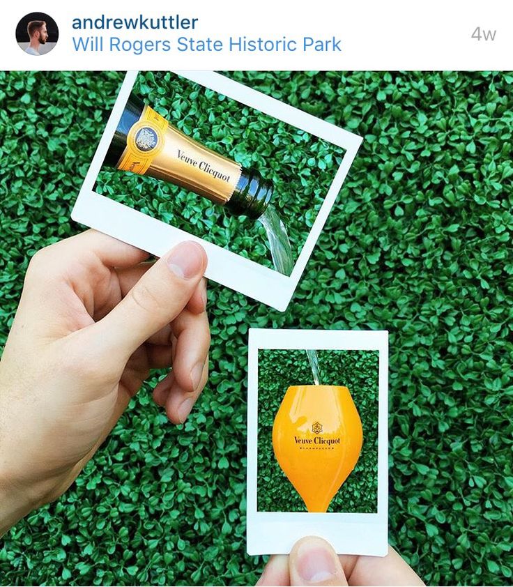 someone is holding an orange and yellow bottle in front of some green grass with two photos