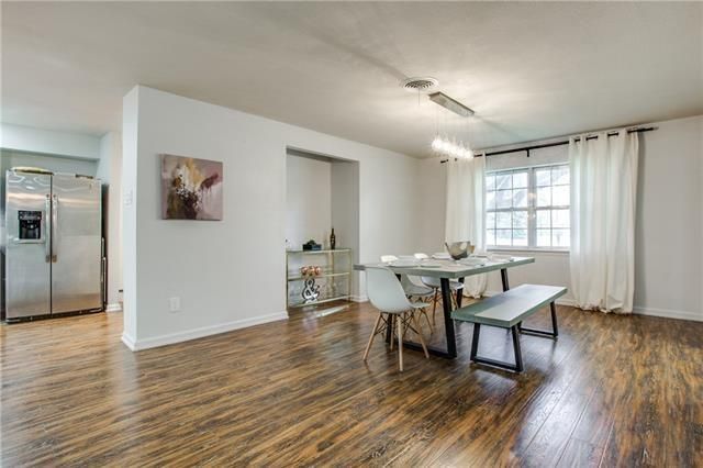 an empty living room with wood floors and white walls