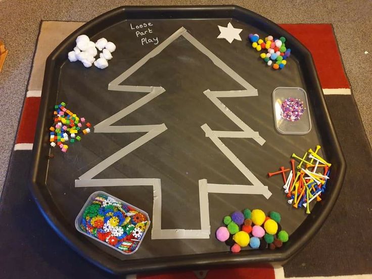 a child's play table with toys on it and a christmas tree drawn on the top