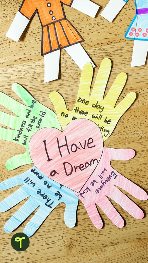 children's handprinted paper cut out to spell i have a dream on a wooden table