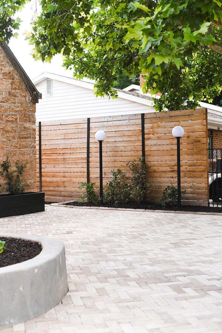 a brick patio and fence surrounding a house