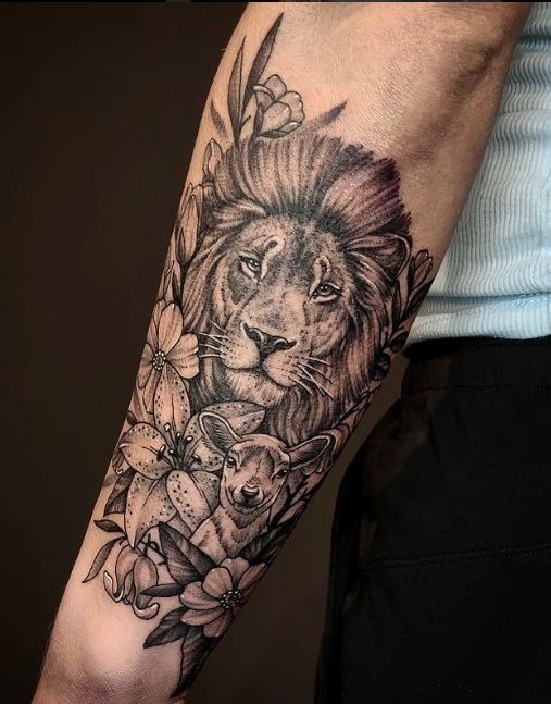 a man with a lion tattoo on his arm and flowers in the middle of his arm