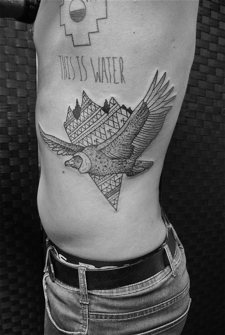 a person with a bird tattoo on their stomach and the words, this is water