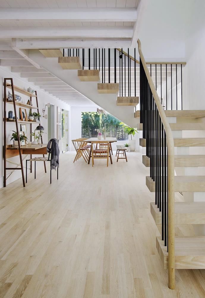 an open floor plan with wood floors and white walls, along with wooden staircases