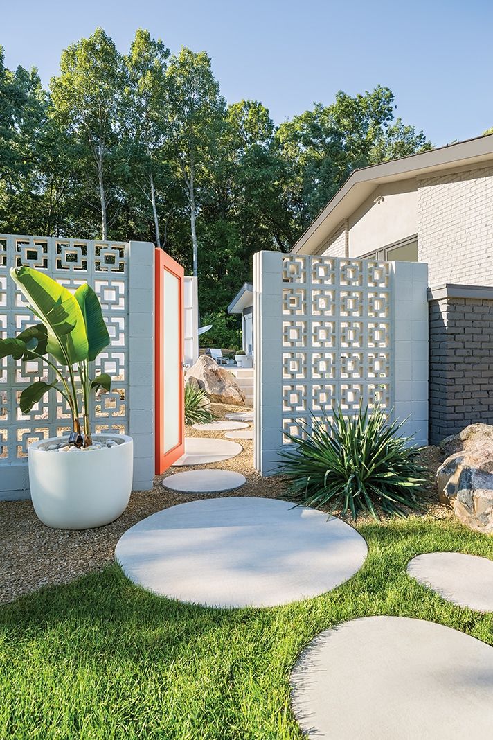 an outdoor garden with white circular stepping stones