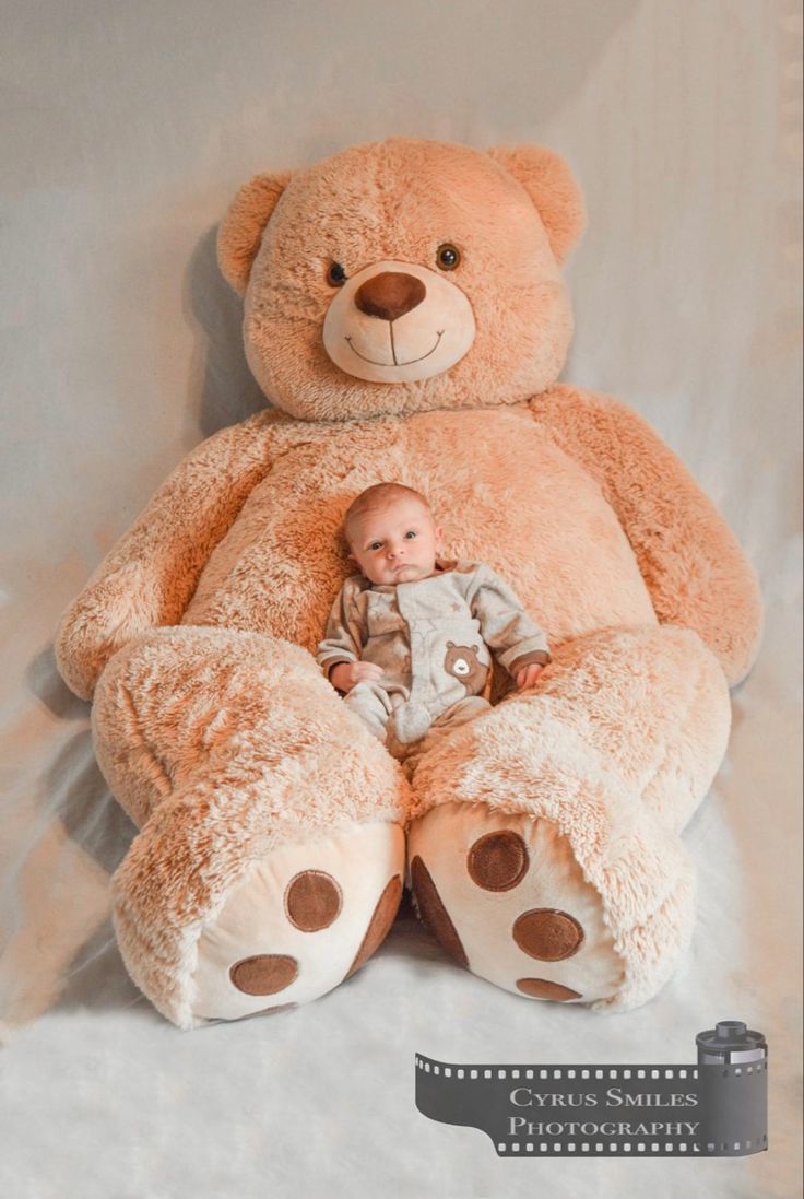 a large teddy bear sitting next to a baby