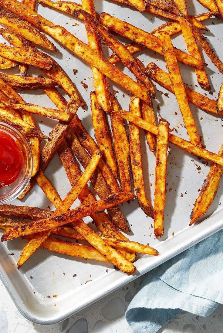 baked french fries with ketchup on a tray