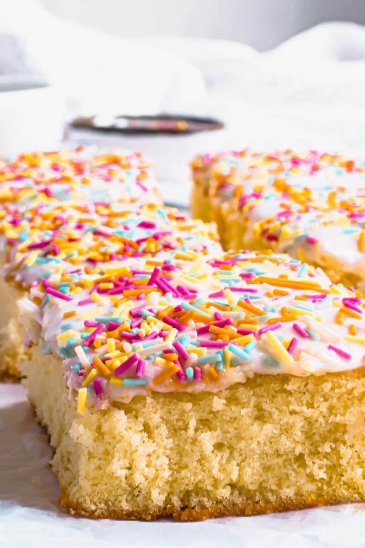 two pieces of cake with white frosting and sprinkles