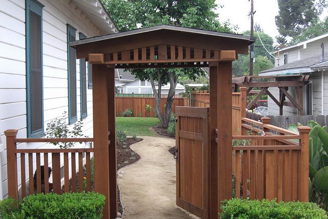 a wooden gazebo sitting in the middle of a yard