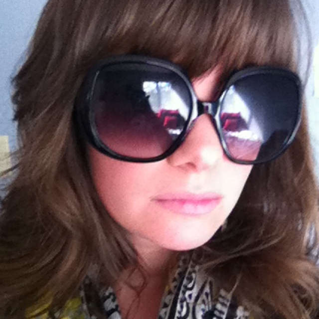 a woman wearing large black sunglasses while taking a selfie