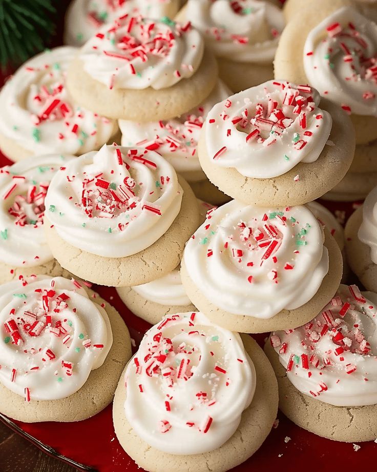 there are many cookies with white frosting and sprinkles on the plate