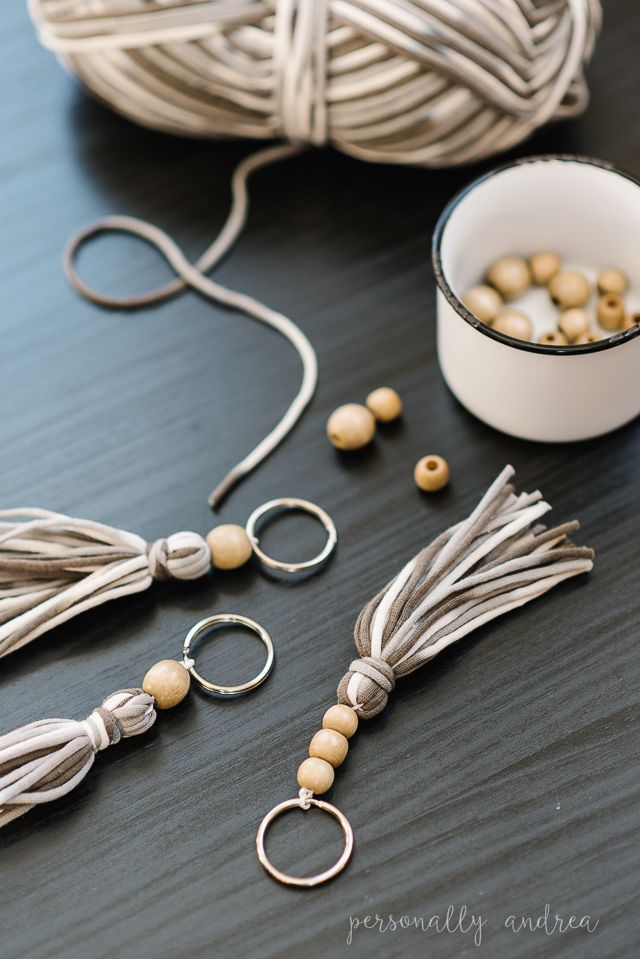 some beads are sitting on a table next to yarn and a bowl with something in it