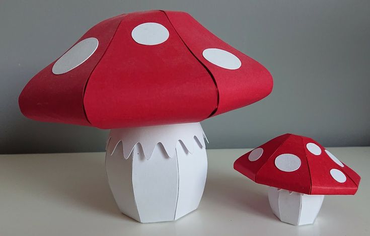 a red mushroom sitting on top of a table next to a white cupcake holder