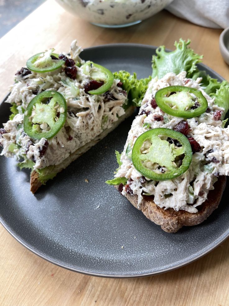 a sandwich with chicken salad and cucumbers on it is sitting on a plate