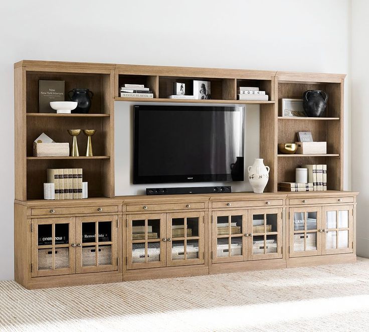 a large entertainment center with bookshelves and a flat screen tv