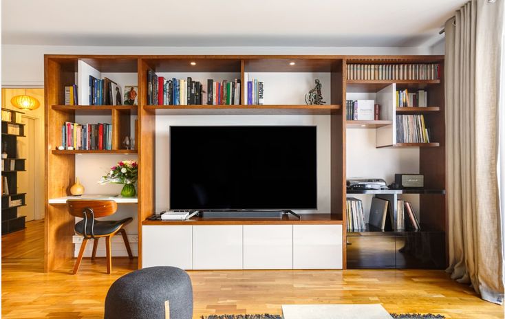 a living room filled with furniture and a flat screen tv sitting on top of a wooden entertainment center