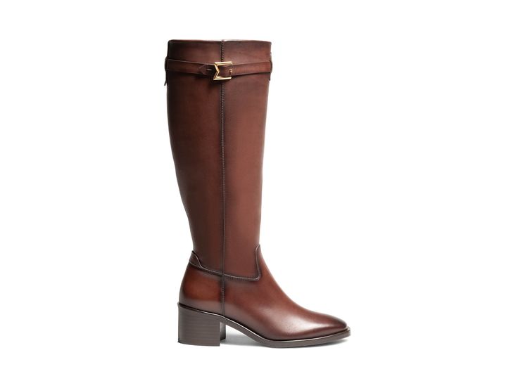 The Maya Rider is the epitome of equestrian inspired elegance, designed with a sleek and modern silhouette that effortlessly commands attention. This fashion-forward riding boot features an inside zipper for easy wear, while the ornamental strap adorned with a gold "M" adds a chic touch. Luxury Calf Leather Knee-high Boots For Business, Luxury Knee-high Boots With Leather Lining For Work, Luxury Leather-lined Knee-high Boots For Work, Luxury Calf Leather Knee-high Boots For Formal Occasions, Luxury Calf Leather Knee-high Boots For Formal Wear, Luxury Knee-high Heeled Boots For Business, Luxury Calf Leather Riding Boots, Elegant Knee-high Riding Boots, Luxury Leather Knee-high Boots For Work