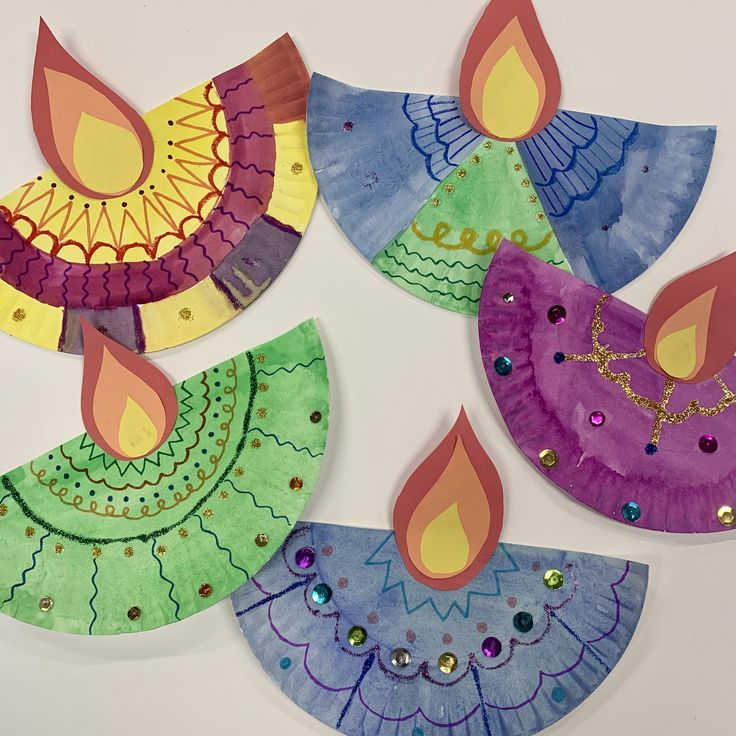 four paper plates with designs on them and one has a lit candle in the middle