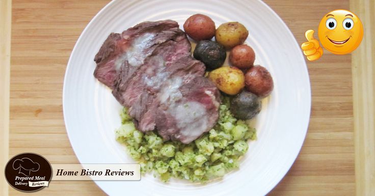 a white plate topped with meat and vegetables next to a smiley face emoticion