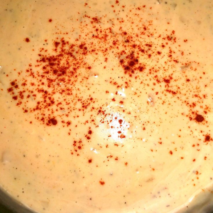 a white bowl filled with soup and topped with brown sprinkles on top