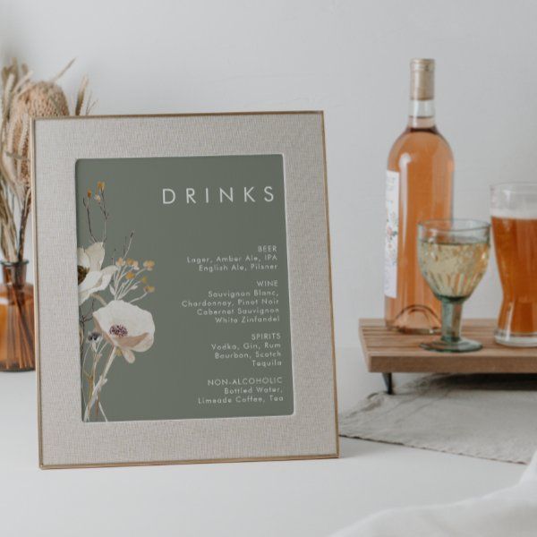 a table topped with bottles and glasses filled with liquid next to a sign that says drinks