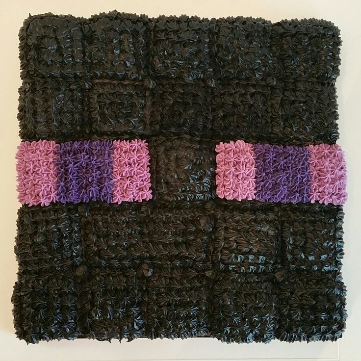 a piece of crocheted material with pink and purple strips on it's sides