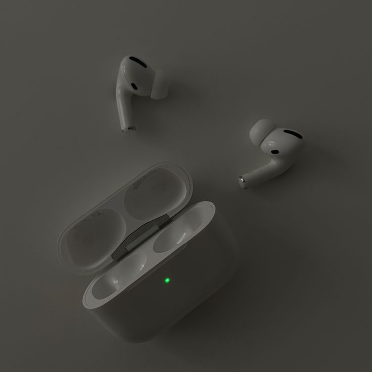 an apple airpods sitting on top of a table next to two other earphones