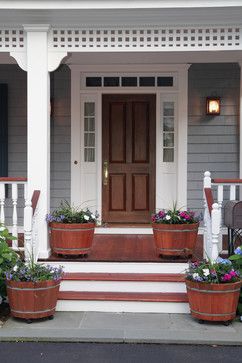 two flower pots on the front steps of a house