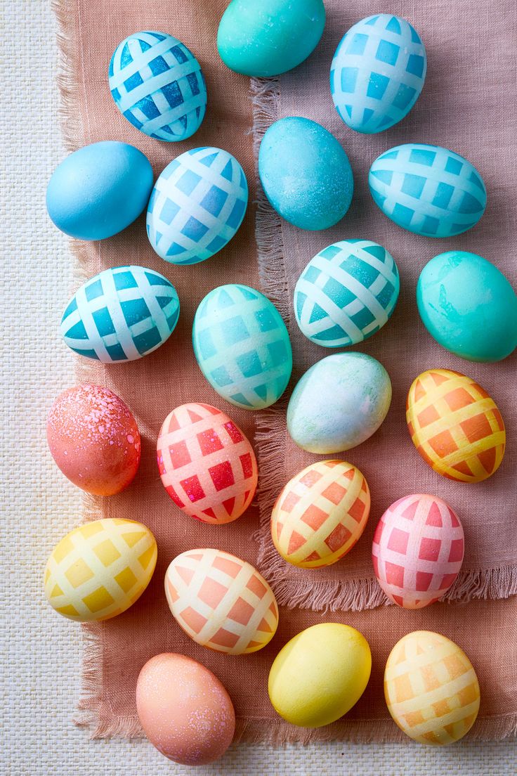 colorful easter eggs laid out on a cloth with different patterns and colors in the middle