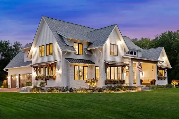 a large white house sitting on top of a lush green field