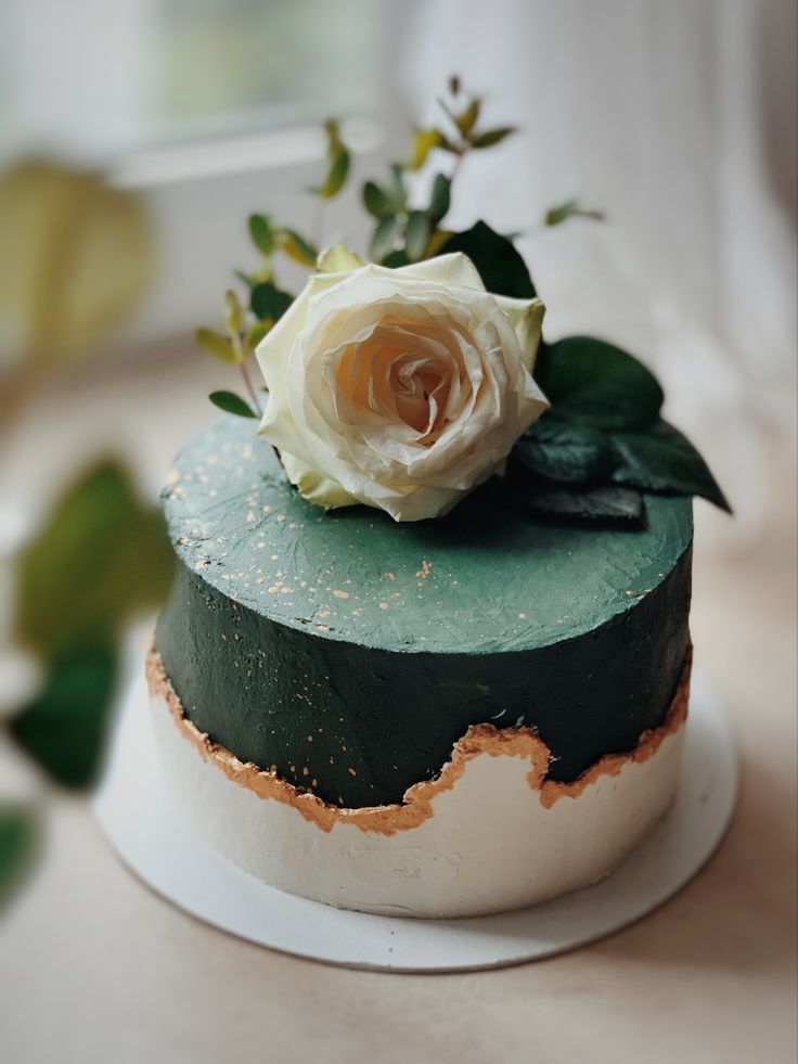 a green and white cake with a flower on top