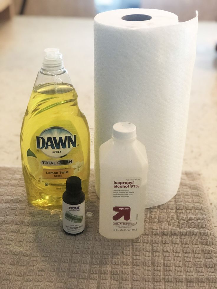 the contents of a toilet paper dispenser and cleaning products are displayed on a table