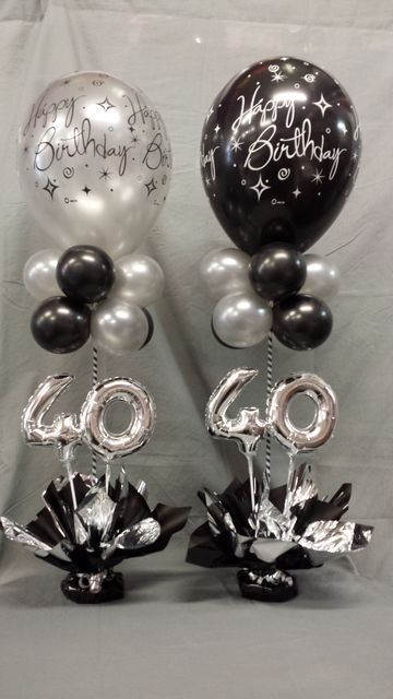 two black and white balloons are next to each other with the words happy birthday written on them