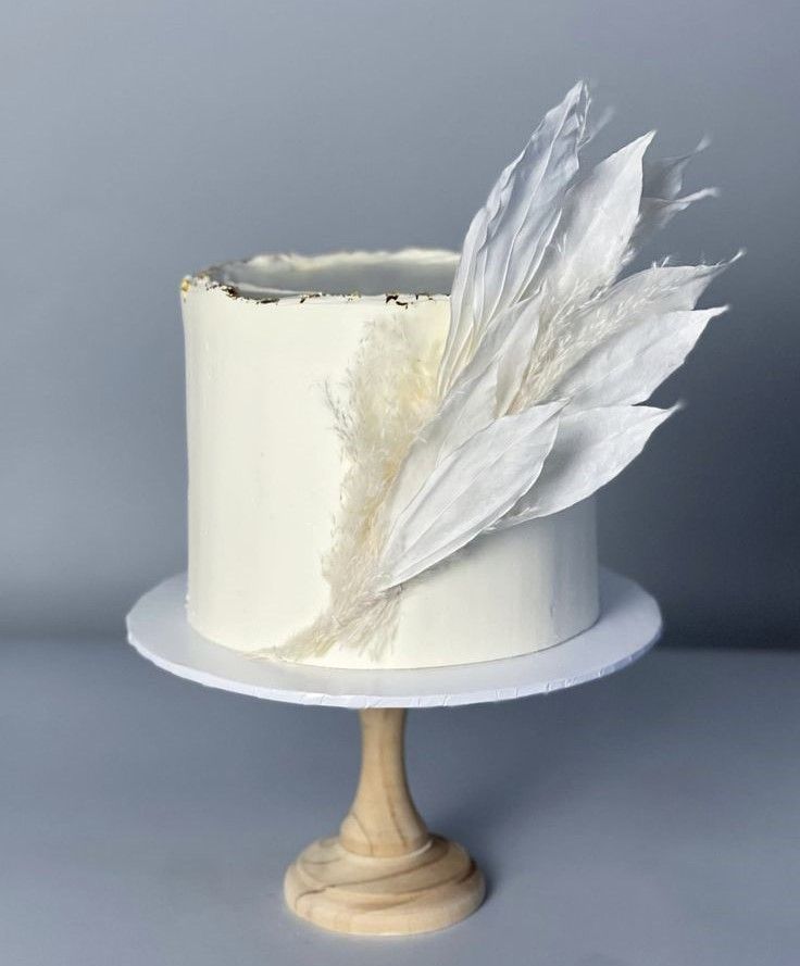 there is a white cake with feathers on it