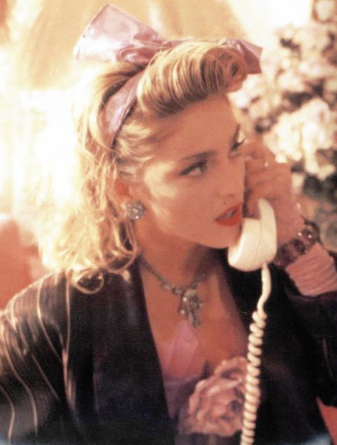 a woman talking on a phone while wearing a bow