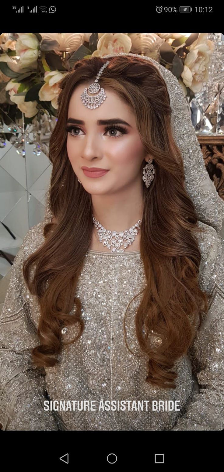 a woman with long brown hair wearing a bridal outfit