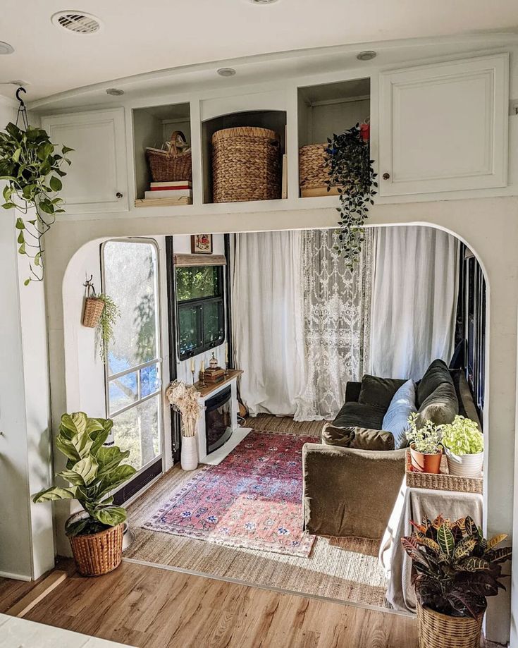 the inside of a recreational vehicle with lots of storage and plants in it's windows