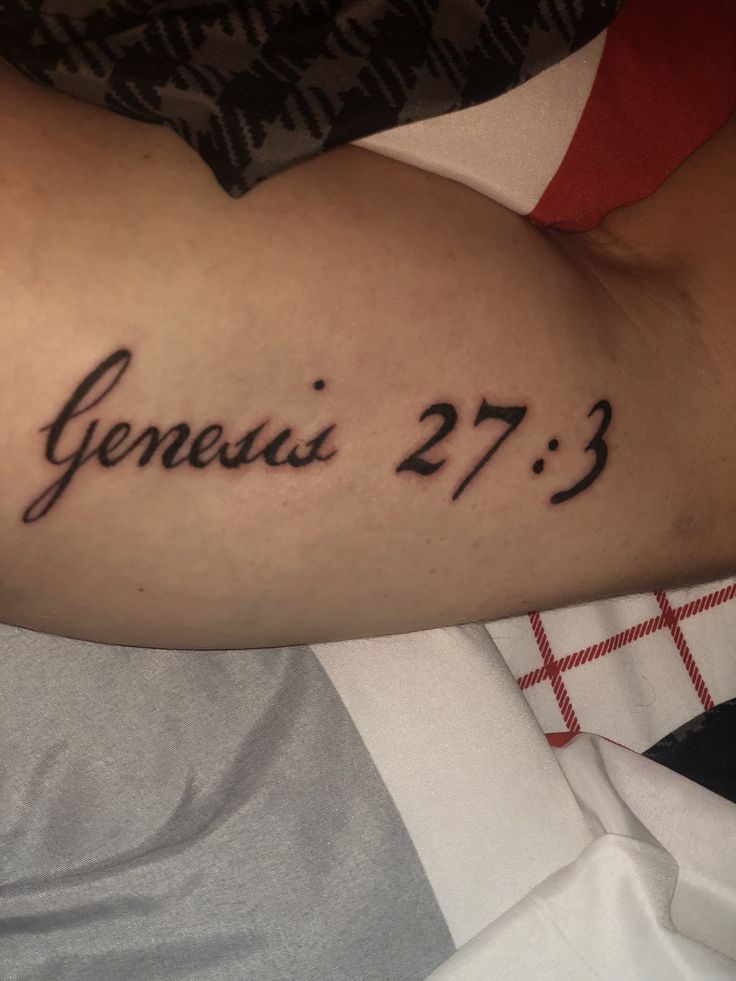 a person with a tattoo on their arm that reads, genius 27 3 and the word jesus is in cursive font