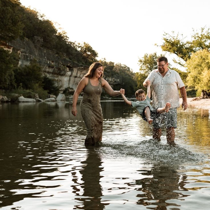 a man, woman and child are playing in the water