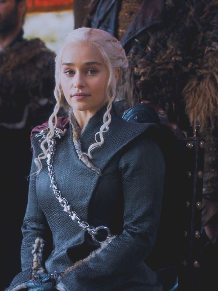 the game of thrones character is sitting in a chair with two men behind her