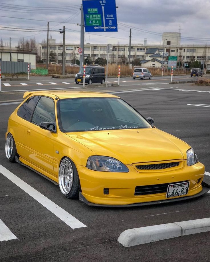 a yellow car parked in a parking lot