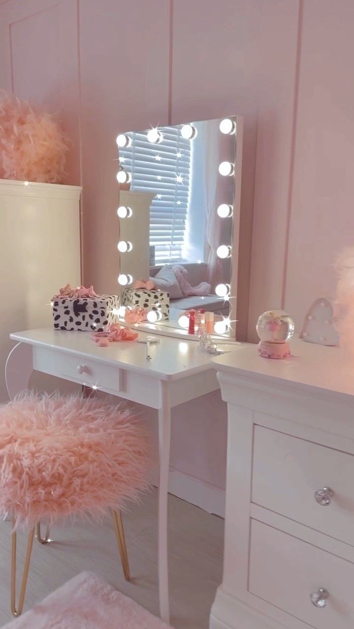 a white desk topped with a mirror and a pink chair covered in fur rugs