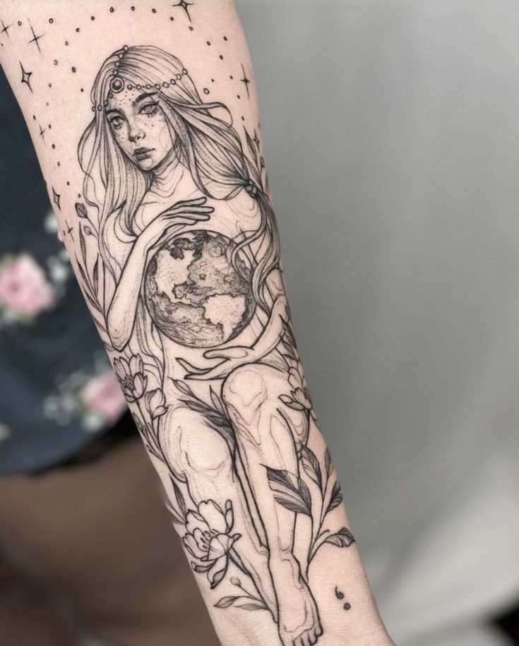 a woman holding the earth tattoo on her arm