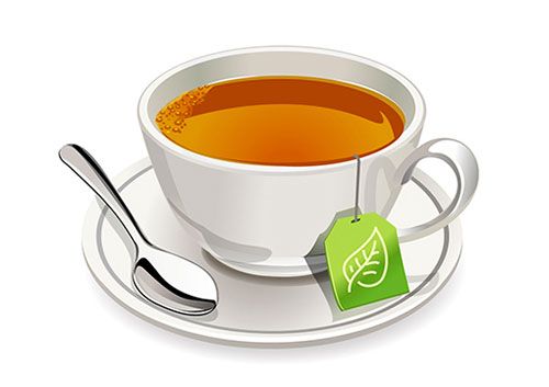 a cup of tea on a saucer with a green tag and spoons next to it