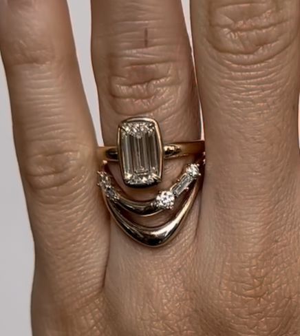 a woman's hand with a ring on it and an emerald stone in the middle