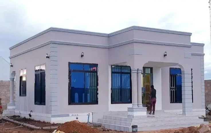 a man standing in front of a house under construction