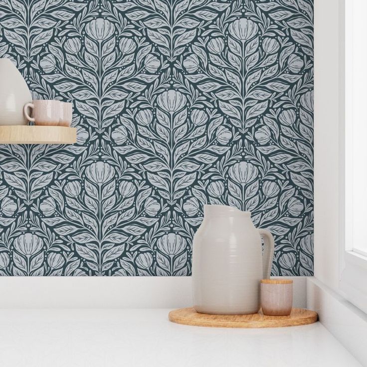 two vases are sitting on a shelf in front of a wallpaper