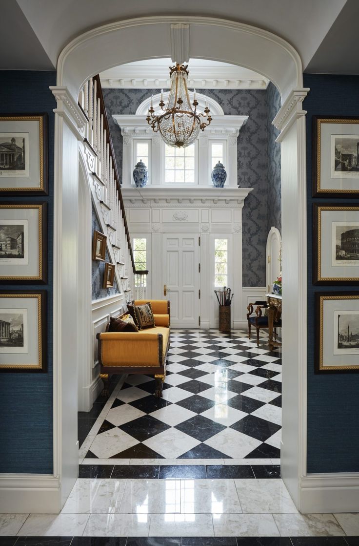 an entry way with black and white checkerboard flooring, chandelier and stairs