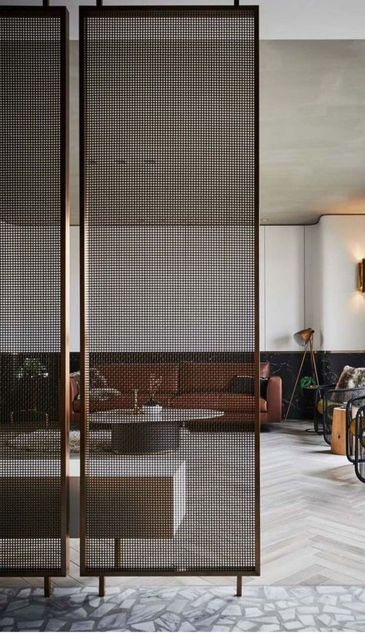 a living room filled with lots of furniture and walls covered in metal mesh coverings